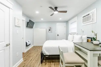 a white bedroom with a bed and a desk at Studio Minutes from Center City South Philly Special in Philadelphia