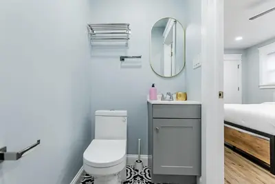 a bathroom with a toilet and a mirror at Studio Minutes from Center City South Philly Special in Philadelphia