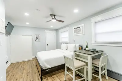 a white bedroom with a bed and a desk at Studio Minutes from Center City South Philly Special in Philadelphia