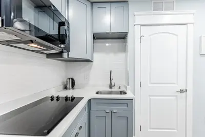 a kitchen with white cabinets and a sink at Studio Minutes from Center City South Philly Special in Philadelphia