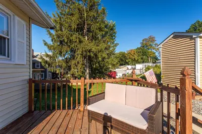 a white chair sitting on a wooden deck at 1 Bus Stop To NYC Room-Free Parking in Hillside
