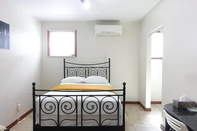 a bedroom with a black bed in a white room at 1 Bus Stop To NYC Room-Free Parking in Hillside
