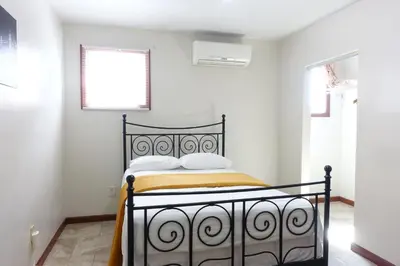 a bedroom with a black bed in a white room at 1 Bus Stop To NYC Room-Free Parking in Hillside