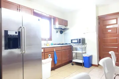a kitchen with a stainless steel refrigerator and wooden cabinets at 1 Bus Stop To NYC Room-Free Parking in Hillside
