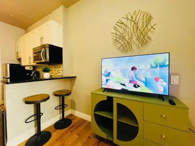a living room with a tv and two stools at The Marlow Midtown in New York