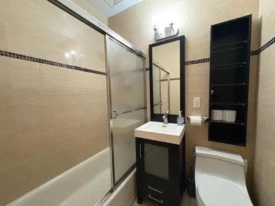 a bathroom with a sink and a toilet and a mirror at The Marlow Midtown in New York