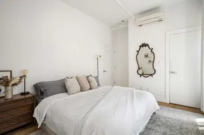 a white bedroom with a large bed and a mirror at Beautiful and Spacious 2 Bed 2 Bath Apt - Elevator in New York
