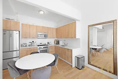 a kitchen with a white table and a table and chairs at Beautiful and Spacious 2 Bed 2 Bath Apt - Elevator in New York