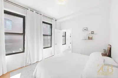 a white bedroom with a bed and a window at Beautiful and Spacious 2 Bed 2 Bath Apt - Elevator in New York