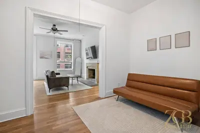 a living room with a couch and a chair at Sun-Filled Brownstone Apt in Prime Chelsea in New York