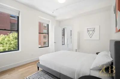 a white bedroom with a bed and a window at Renovated 2 Bed 2 Bath Apt in Prime Midtown - Elevator - Laundry in New York
