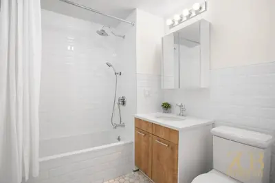 a white bathroom with a sink and a shower at Renovated 2 Bed 2 Bath Apt in Prime Midtown - Elevator - Laundry in New York