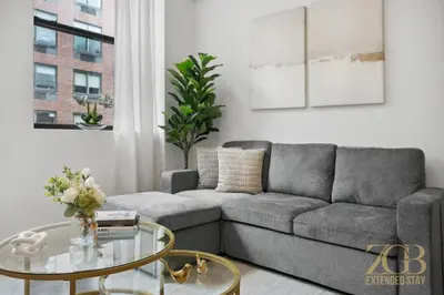 a living room with a couch and a glass table at Newly Renovated 1 Bedroom Apt - Elevator - Laundry in New York