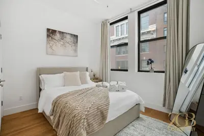 a bedroom with a large bed and a window at Newly Renovated 1 Bedroom Apt - Elevator - Laundry in New York