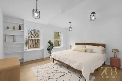 a white bedroom with a large bed and a window at State-of-the-Art Loft-Style 2Br Apartment - Laundry - Chelsea in New York