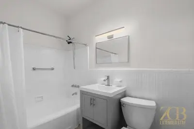 a white bathroom with a sink and a toilet at State-of-the-Art Loft-Style 2Br Apartment - Laundry - Chelsea in New York