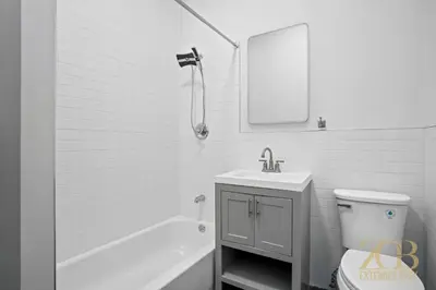 a bathroom with a sink and a toilet and a mirror at Classic NYC Brownstone 2Br Apartment in Prime Chelsea in New York