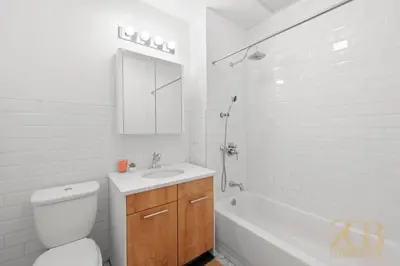 a white bathroom with a sink and a toilet and a tub at Beautifully Renovated Studio in Prime Manhattan in New York