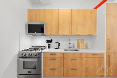 a kitchen with a stove and a sink and a microwave at Beautifully Renovated Studio in Prime Manhattan in New York