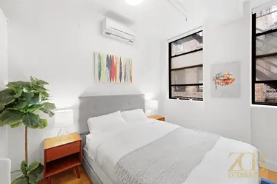 a white bedroom with a bed and a window at Beautifully Renovated Studio in Prime Manhattan in New York