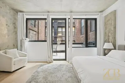 a bedroom with a bed and a chair and windows at Modern 2BR Terrace WD & Elevator in NoMad in New York