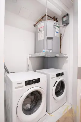 a laundry room with a washing machine and a washer at Modern 2BR Terrace WD & Elevator in NoMad in New York