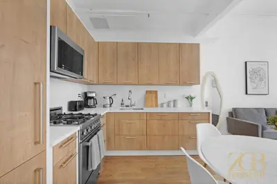 a kitchen with wooden cabinets and a stove top oven at Beautifully Renovated 1 bedroom in Prime Manhattan in New York