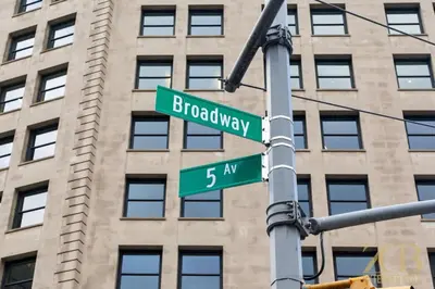 two green street signs on a pole with a building at Spacious 3BR Flex 4 with Washer & Dryer in NoMad in New York