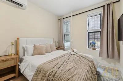 a white bedroom with a bed and a window at Chic 3BR 2BA West Village Apt with Private Oasis in New York