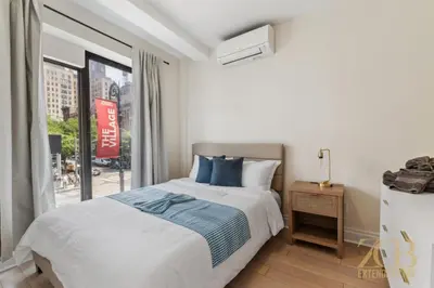 a bedroom with a bed and a large window at Chic 3BR 2BA West Village Apt with Private Oasis in New York