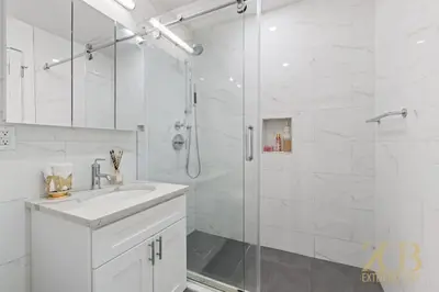 a white bathroom with a sink and a shower at Chic 3BR 2BA West Village Apt with Private Oasis in New York