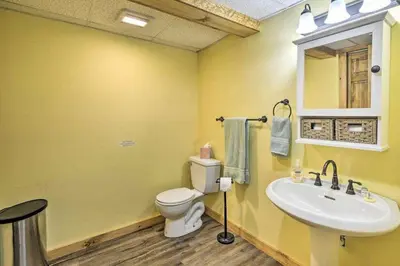 a yellow bathroom with a toilet and a sink at Log Cabin And Cottages At Equestrian House in Pleasant Mount