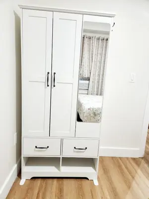 a white cabinet with a mirror in a room at Cozy 2BR in Newark for Families, Work & Long Stays in Newark