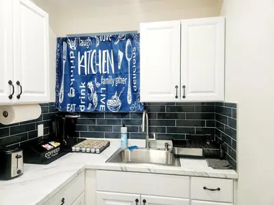 a kitchen with a sink and a black tile wall at Cozy 2BR in Newark for Families, Work & Long Stays in Newark
