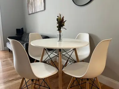 a white table and chairs with a vase of flowers on it at Cortland Manhattan Suites in New York