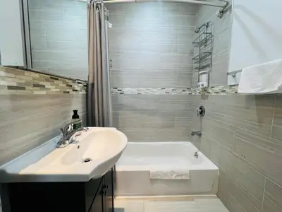 a bathroom with a sink and a bath tub and a sink at Cortland Manhattan Suites in New York