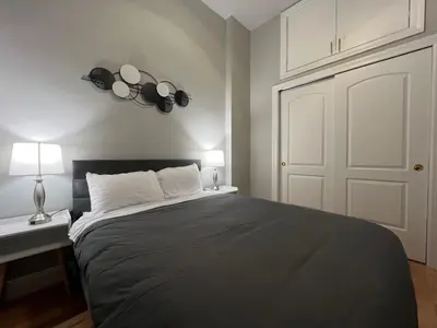 a bedroom with a large bed and a white door at Cortland Manhattan Suites in New York