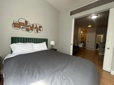 a bedroom with a large bed with a green headboard at Cortland Manhattan Suites in New York