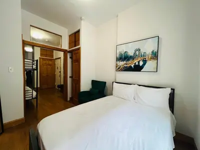 a bedroom with a white bed and a chair at The Kensington on 44th in New York