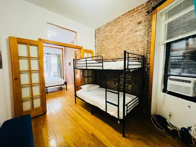 a room with two bunk beds and a brick wall at The Kensington on 44th in New York