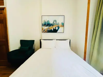 a bedroom with a white bed and a chair at The Kensington on 44th in New York
