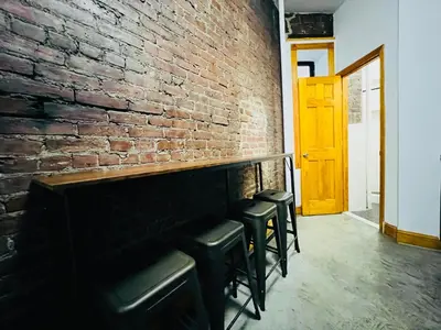 a brick wall with stools in front of a fireplace at The Kensington on 44th in New York