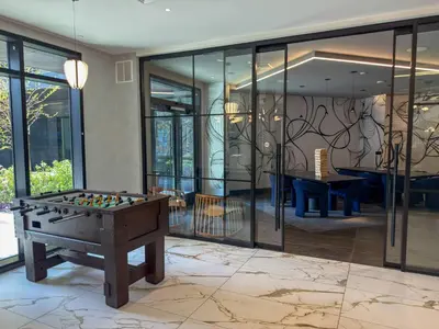 a room with a pool table in front of windows at Luxury Stay Near NYC | Full Access to Amenities in Newark