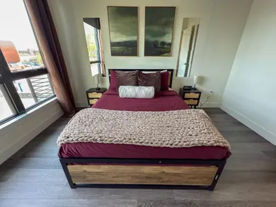 a bedroom with a large bed in a room with windows at Luxury Stay Near NYC | Full Access to Amenities in Newark
