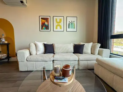 a living room with two couches and a glass table at Luxury Stay Near NYC | Full Access to Amenities in Newark