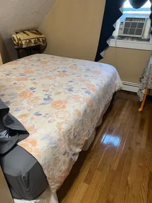 a bedroom with a bed with a floral comforter at Cozy room with Queen bed 20 min to NYC in Ridgefield Park