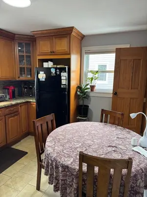 a kitchen with a table and a black refrigerator at Cozy room with Queen bed 20 min to NYC in Ridgefield Park