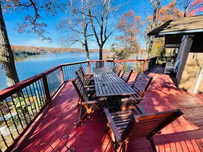 a picnic table on a deck with a view of a lake at Villa Adriana 4bdr 2 bath lake front dream home in Vernon