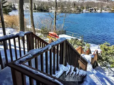 a wooden staircase with snow on it next to a lake at Villa Adriana 4bdr 2 bath lake front dream home in Vernon