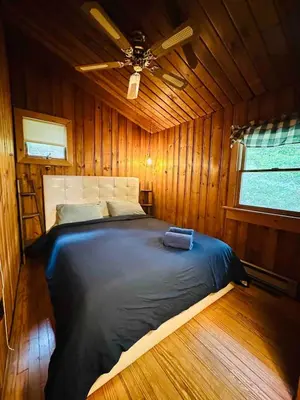 a bed in a wooden room with a ceiling at Villa Adriana 4bdr 2 bath lake front dream home in Vernon